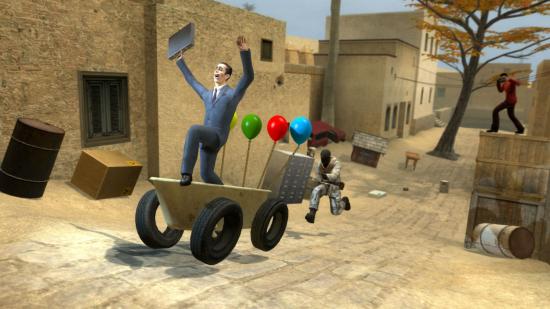 Sandbox games - Garry's Mod: A man in a suit travels up the road on a bath on wheels while another man pursues him