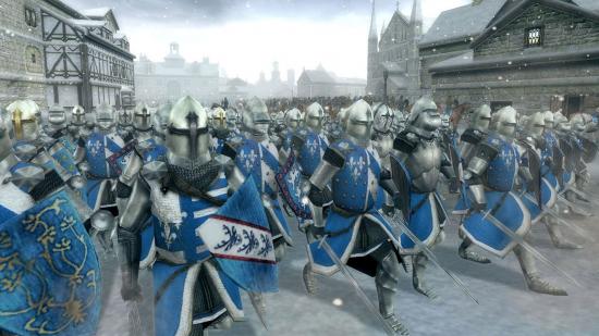 Los mejores juegos medievales: soldados que marchan a través de una ciudad cubierta de nieve en Total War: Medieval 2
