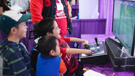 A child plays Fifa with an accessible joystick setup.