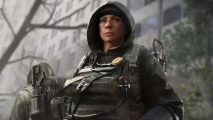 The Division 2 update rolls back proficiency ranks: A female agent wearing a vest with oxygen cannisters secured to it looks off into the distance from under her hood.