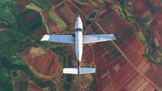 Light aircraft flying over fields in Microsoft Flight Simulator