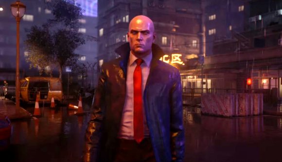 Hitman freelance mode: Agent 47 stands in the rain at night on a neon-lit Chongqing street