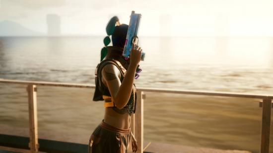 Character V holding a pistol by the beach in Cyberpunk 2077