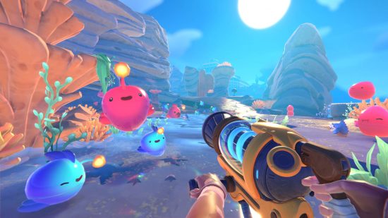 Best games like Pokémon - several happy-looking slimes are bouncing around Rainbow Island in Slime Rancher 2.