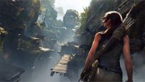 Shot of Lara Croft, on a ledge in an overgrown jungle temple, staring at a stone face, facing broken wooden bridges