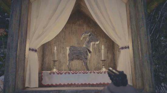 One of the many goats of warding in Resident Evil Village. This one is in a shrine with candles either side.