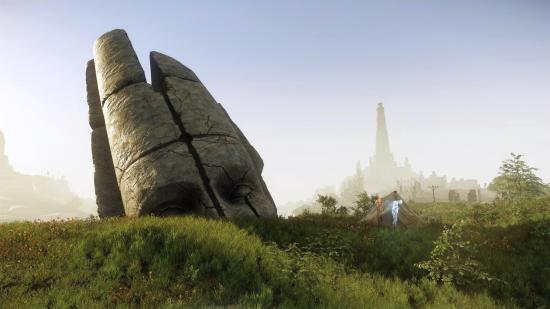 A colossal stone head lies half-buried in a grassy hill in New World's fantastical island of Aeternum. A tent lies next to the head, haunted by a ghostly spirit, while a tower looms in the background.