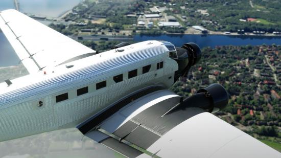 Microsoft Flight Simulator's Junkers JU-52 craft flying above fields and villages