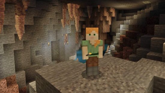 Minecraft Dripstone Caves: Alex staat in de Minecraft Dripstone Cave met stalactieten op de achtergrond en ontginbaar koper op de muur achter haar.