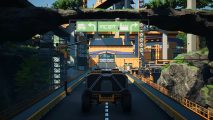 A wheeled transport vehicle passes underneath new traffic signs available in Satisfactory's Update 5.