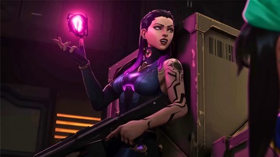 Valorant Tier List: Reyna, en B-Tier-agent, tar skydd bakom en struktur och förbereder sin nästa attack, med en glödande rosa orb som flyter över ena handen och en pistol i den andra
