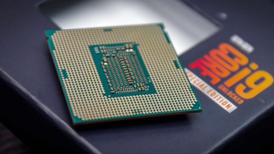 Upgrade CPU s procesorem Intel Core i9, který sedí s jeho kolíky tváří v tvář nahoru na jeho maloobchodní krabici