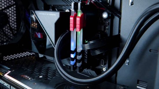 Как да изградите игрален компютър: Две пръчки RAM с червени акценти седят в дънната платка, до охладителя на процесора