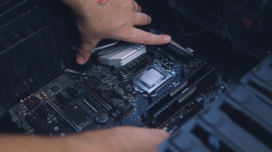 How to build a gaming PC: someone places the motherboard into the case