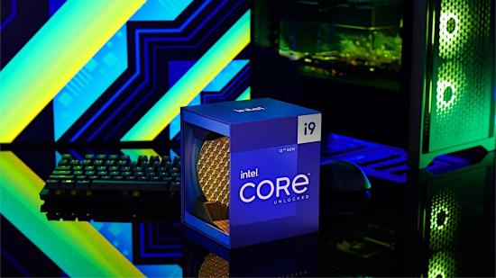 The Intel Core i9 12900K retail packaging, sitting front and centre with a gaming PC and keyboard behind it