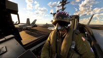 Microsoft Flight Simulator Top Gun DLC: A pilot wearing a helmet marked 'Maverick' taxis in an F/A-18E Super Hornet on the deck of an aircraft carrier as the sun sets in the background against a blue partially cloudy sky.