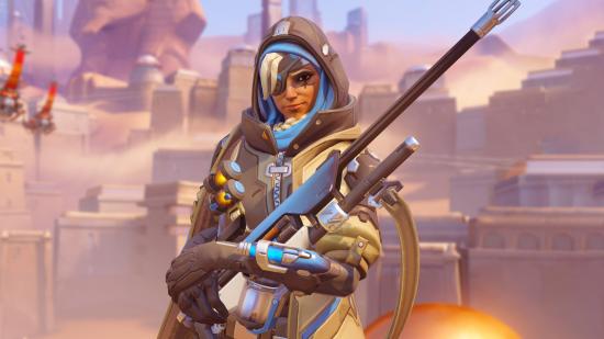 Overwatch 2 Beste Support Heroes: Ana houdt haar biotische geweer in beide handen voor een woestijnachtergrond