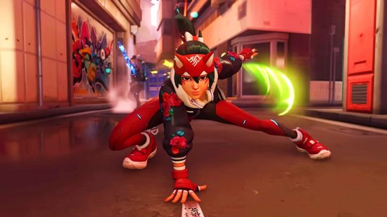 Overwatch 2 hero Kiriko, a teal-haired woman in a red and black ninja costume with fox ears on a headband, crouches with one palm on the floor in a 