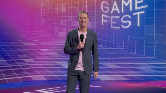 Summer Game Fest start time: Geoff Keighley holds a mic as he stands in front of an abstract background with purple and magenta patterns