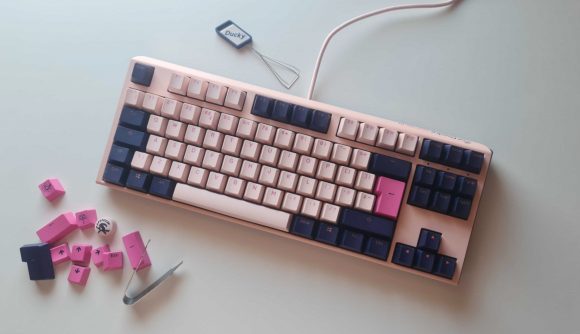 Ducky One 3 review - Fuji TKL edition: the pretty pink gaming keyboard lays on the desk next to its extra keycaps