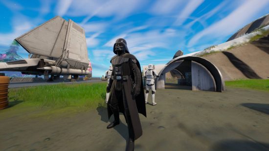 Fortnite Darth Vader - Vader is standing in an Imperial landing zone, flanked by two Stormtroopers.