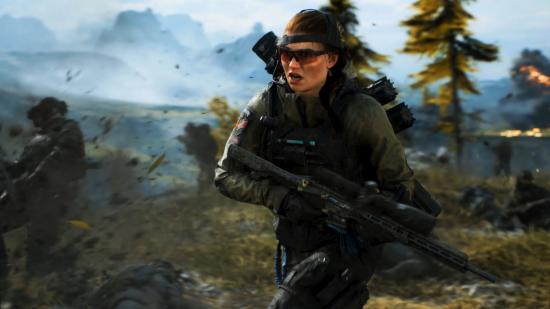 Battlefield 2042 Season One: New specialist Ewelina Lis runs into battle carrying a modern rifle as mud and shrapnel explode around her.
