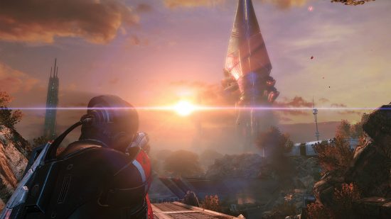 Best space games: A character in futuristic clothes looking at the sun setting on an alien planet in Mass Effect: Legendary Edition.