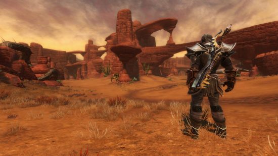 Best single-player MMOs: A character in plate armour stands in a desert surrounded by red bluffs in Kingdoms of Amalur: Reckoning.