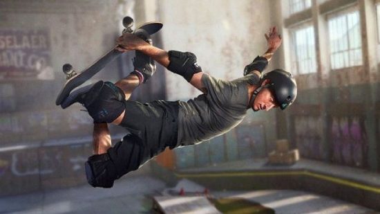 Tony Hawk's Pro Skater 3 and 4 remaster: Tony Hawk perfroms a grab in a grimy warehouse skate park, wearing a black helmet, grey shirt, black shorts, and black pads
