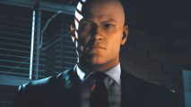 Hitman 3 new map: Agent 47 looks at the camera from a darkened room
