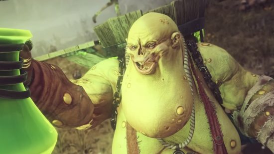 Total War: Warhammer 3 Festus the Leechlord DLC: Festus, a green chaos daemon with with a pendulous goiter and a missing nose, grins as he looks at a glowing green concoction he holds in a bottle in his right hand