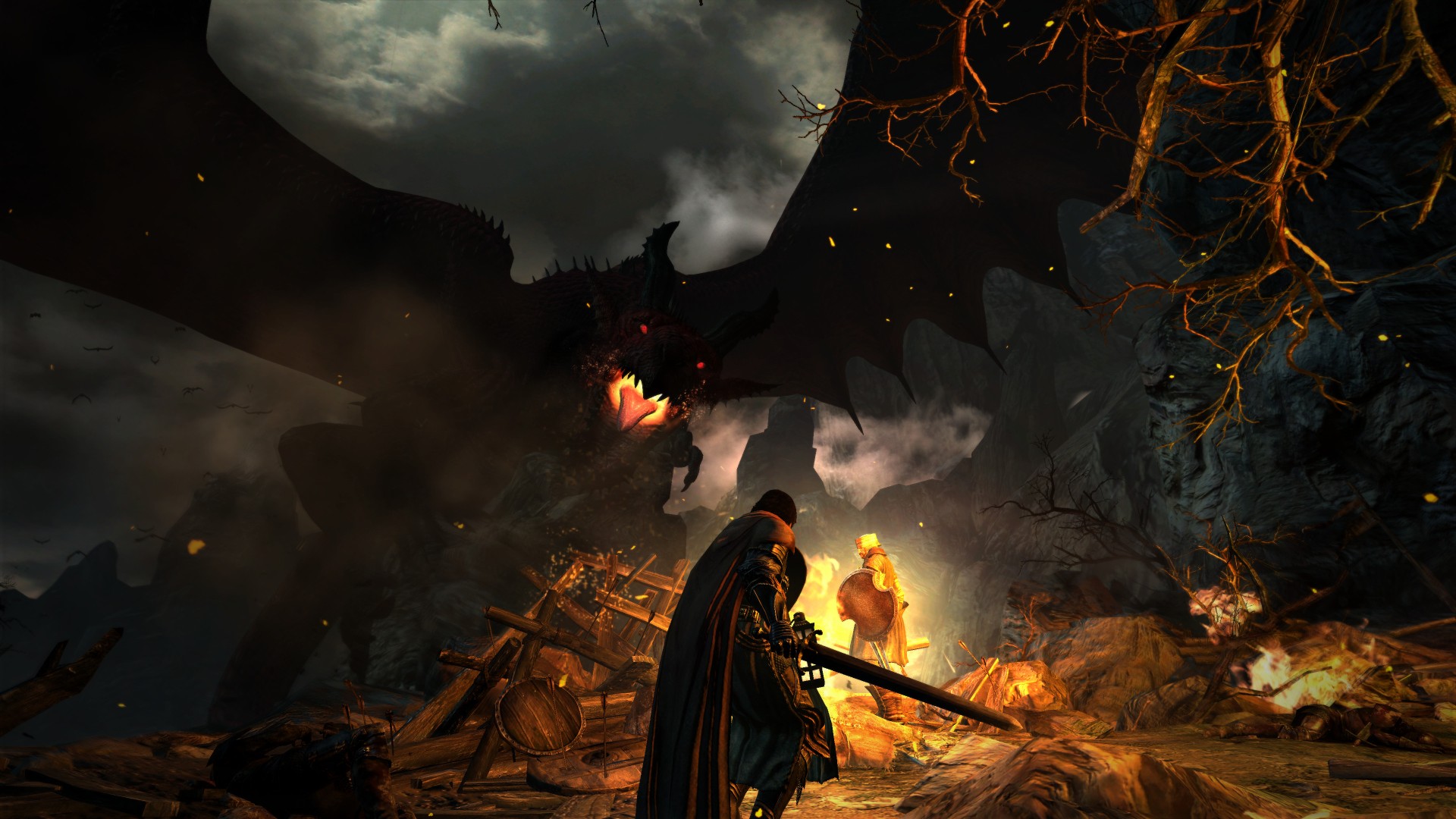 Best dragon games: Dragon's Dogma: Dark Arisen. Image shows a dragon approaching people at a camp fire in the dark.