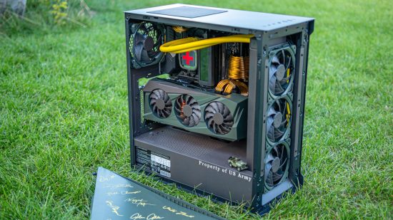 A custom gaming PC mod in army green pays homage to the MASH TV show, sitting on grass
