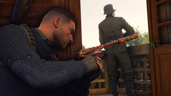 Sniper Elite 5 update: Karl Fairburne readies a suppressed pistol as he crouches behind a doorway that leads out onto a balcony where a German soldier stands guard, unaware of his presence.