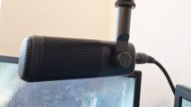 The Elgato Wave DX XLR microphone is suspended above a gaming monitor
