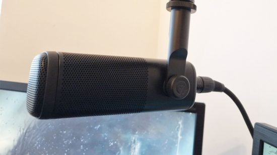 The Elgato Wave DX XLR microphone is suspended above a gaming monitor