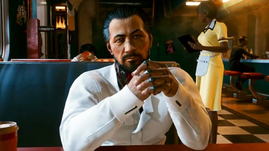 Cyberpunk 2077 - Takemura, a bearded man in a white suit, sits at a table in a crowded diner, his hands clasped together and elbows resting on the table