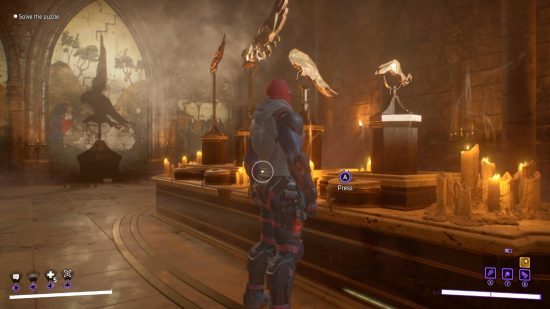 Gotham Knights Owl Puzzle：Red Hoodは、壁画の後ろにスポットライトが輝くように変わる4つの彫像とボタンを見ています。彫像の部分は壁画に影を落とします。チャンバーはろうそくの光で照らされています。
