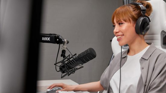 Woman with red hair using Rode X microphone on arm at desk