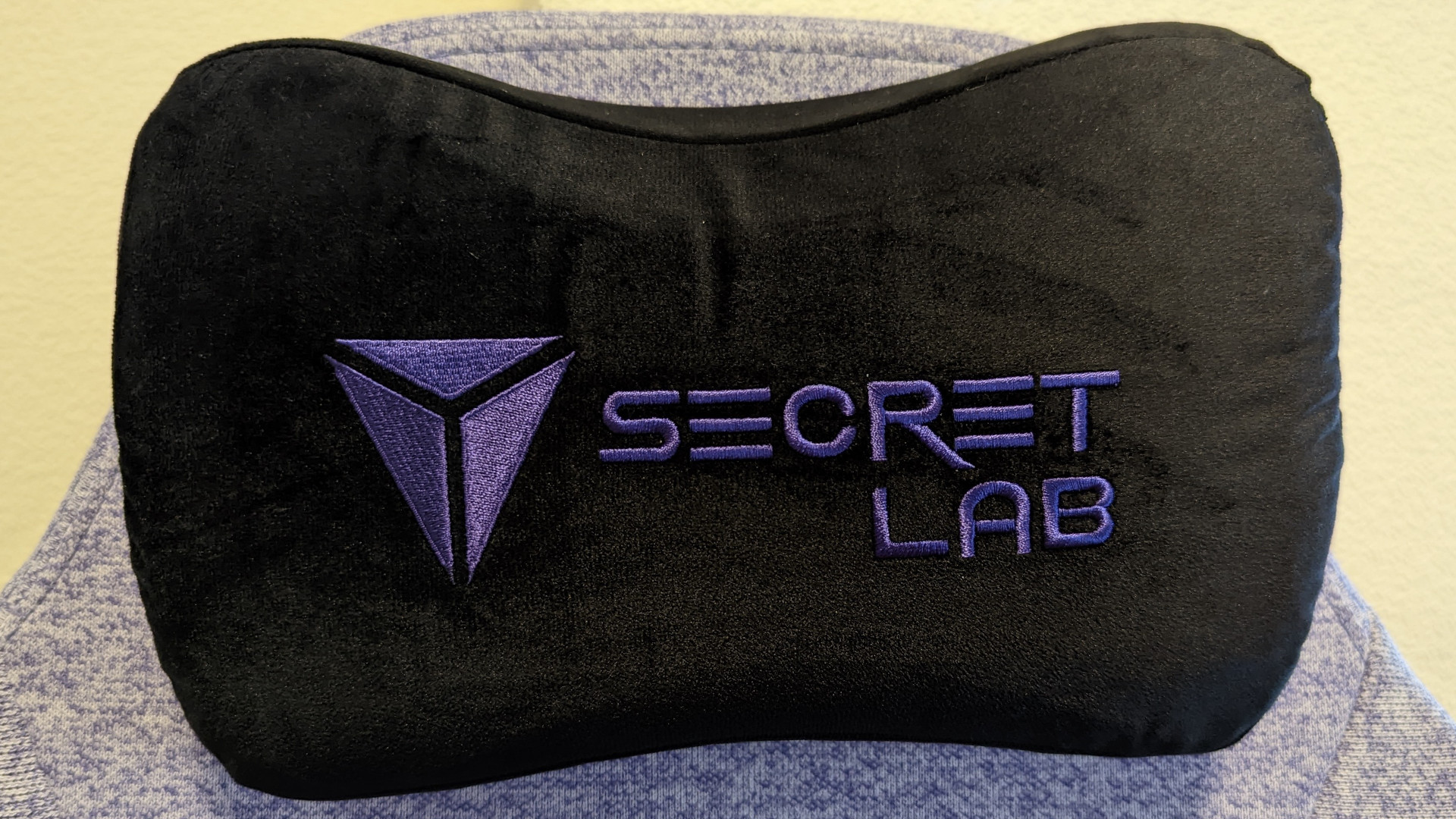 The Secretlab logo on its blakc magnetic memory foam head pillow
