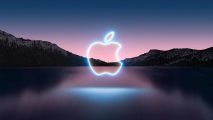 A blue neon Apple logo glows over the horizon of a lake and mountains