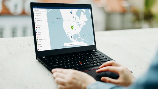 NordVPN review: someone uses the Windows app on a laptop on a balcony