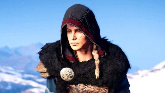 Assassin's Creed: Valhalla DLC - female Eivor wearing her hood up in a crisp open-air day, snowy mountains behind her