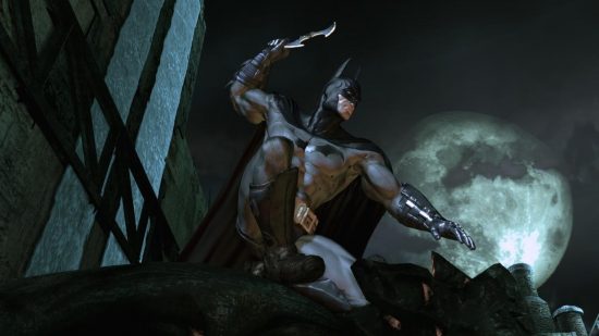 Best Batman games - Batman poised to throw a Batarang while on top of a grotesque in Arkham Asylum.