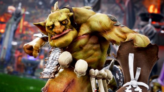 New Blood Bowl 3 release date: An orc wearing leather wrist guards and a bandolier of skulls and bones grimaces at the camera