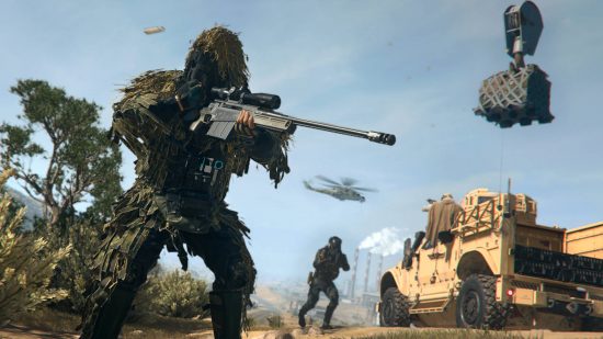 How to buy back teammates Warzone 2 - a soldier in a ghillie suit aiming a sniper rifle as his teammate approaches an APC in the desert. A helicopter flies overhead.
