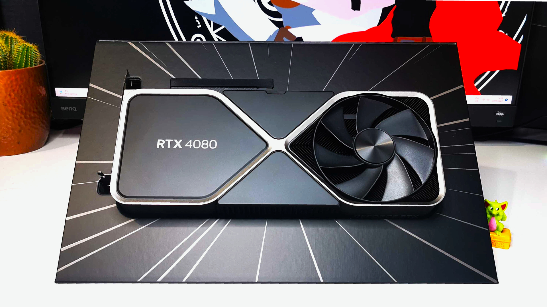 Nvidia RTX 4080 graphics card sitting in GeForce packaging on white desk
