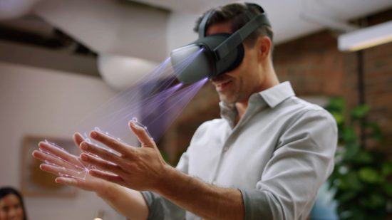 A man wearing a Meta Quest 2 VR headset looks at his hands, using hand-tracking