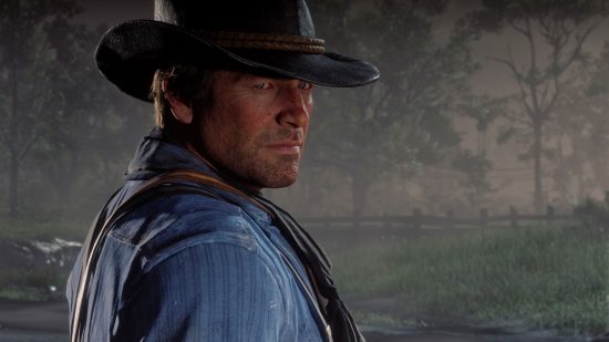 A man in a blue shirt and cowboy hat looking pensive in the countryside in Red Dead Redemption 2, one of the best offline games