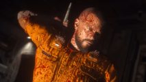 Callisto Protocol PC stutters: Jacob Lee, the protagonist of The Callisto Protocol, stands among the industrial ruin of Black Iron prison, stands in the darkness covered in blood.